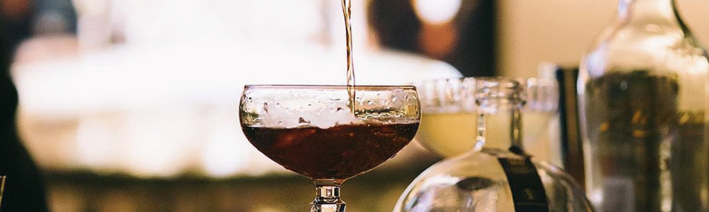 Bartender preparing cocktails at a professional stainless steel bar station during a party